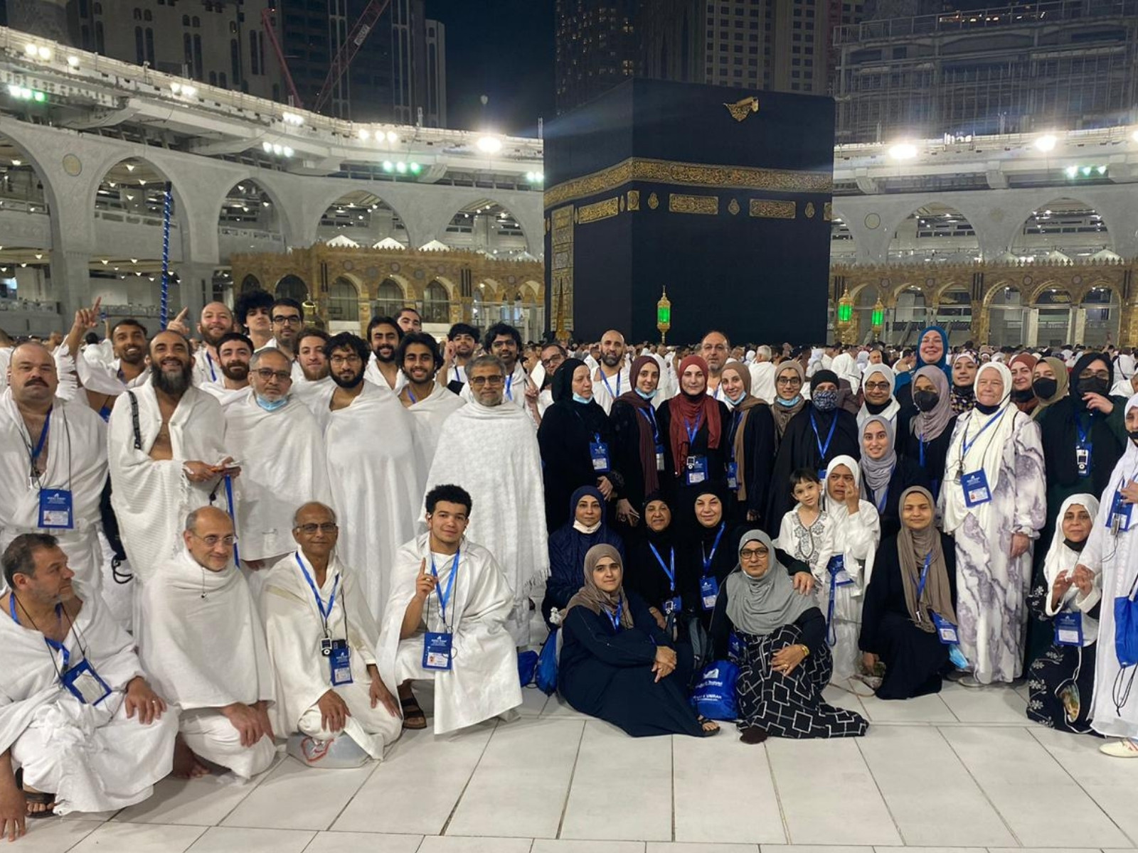 Group of brothers and sisters in ihram in front of the Kaʿbah